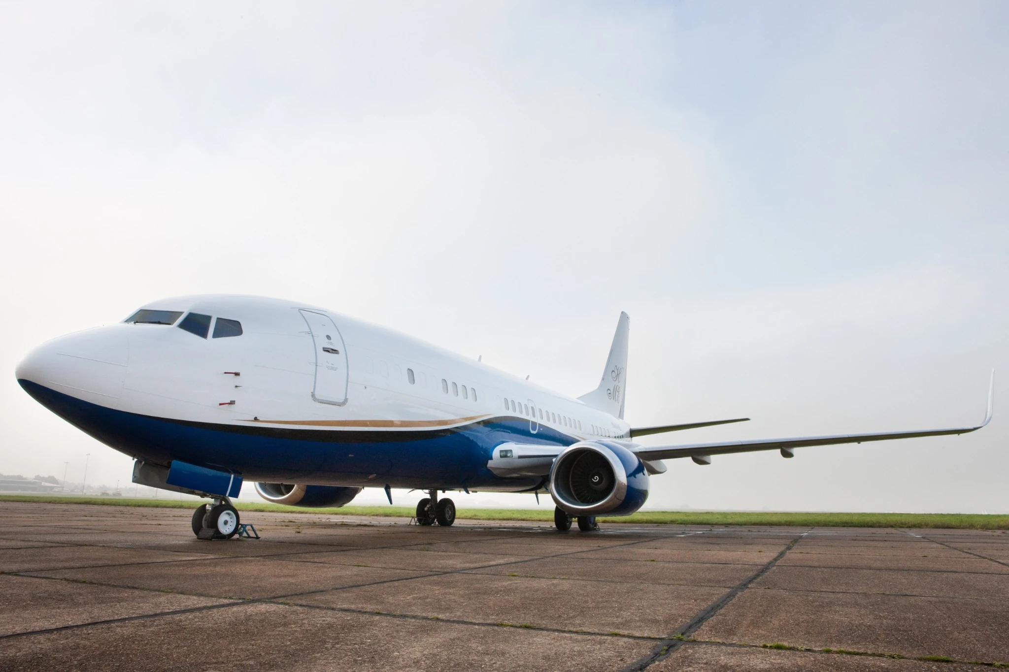 Boeing 737 VIP N44HE on the apron, with a white fuselage, navy lower body and winglets